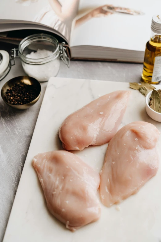 two pieces of chicken sitting on top of a cutting board, by Julia Pishtar, trending on pexels, renaissance, smooth marble surfaces, 6 pack, bald lines, sparkling