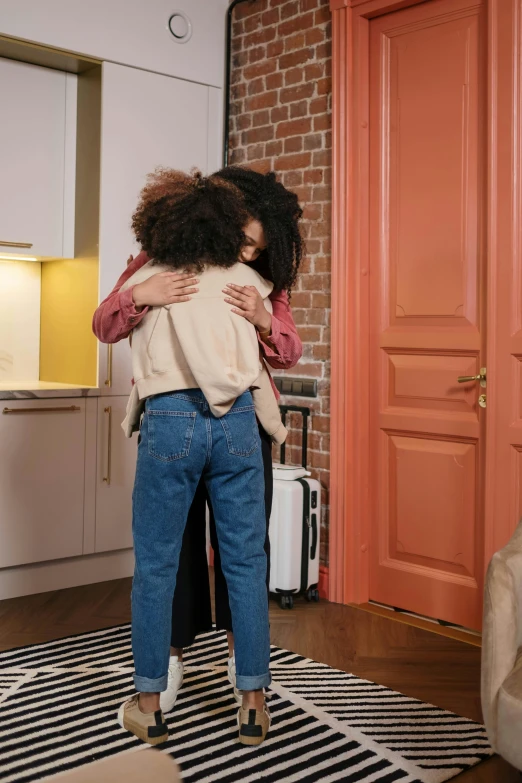 two women hugging each other in a living room, pexels contest winner, happening, leaning on door, ashteroth, leaving a room, in a kitchen