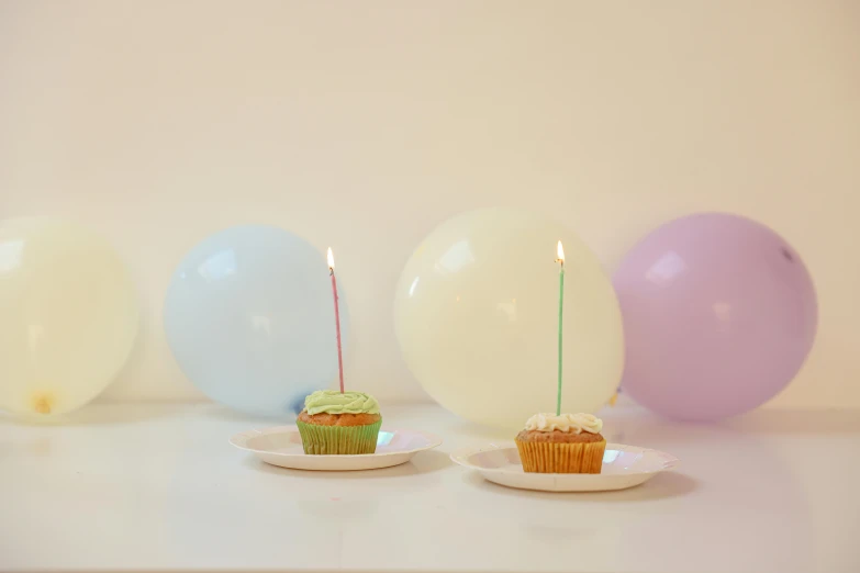 a cupcake sitting on top of a plate next to balloons, unsplash, hyperrealism, holding a candle holder, pastel green, adult pair of twins, background image