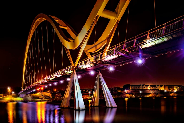 a bridge over a body of water at night, by Derek Hill, pexels contest winner, art nouveau, gold cables, pembrokeshire, where a large, thumbnail