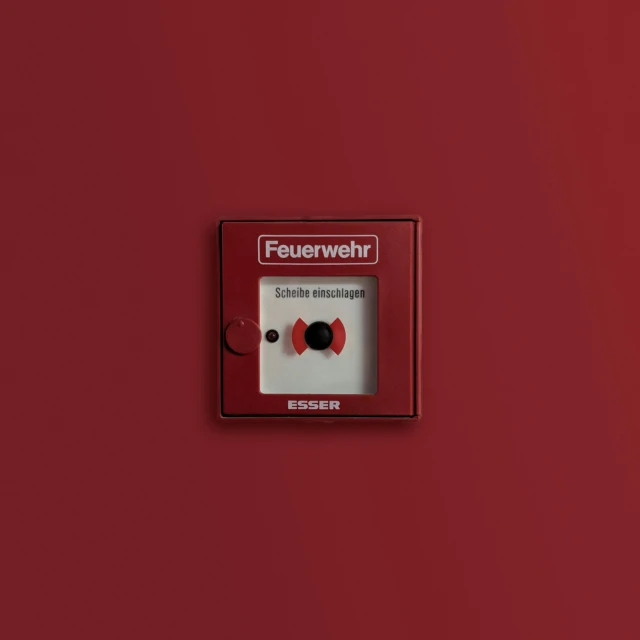 a red fire hydrant sitting on top of a red wall, an album cover, inspired by Heinz Anger, unsplash contest winner, bauhaus, electrical case display, ffffound, text says: schwarzlicht, embellisher