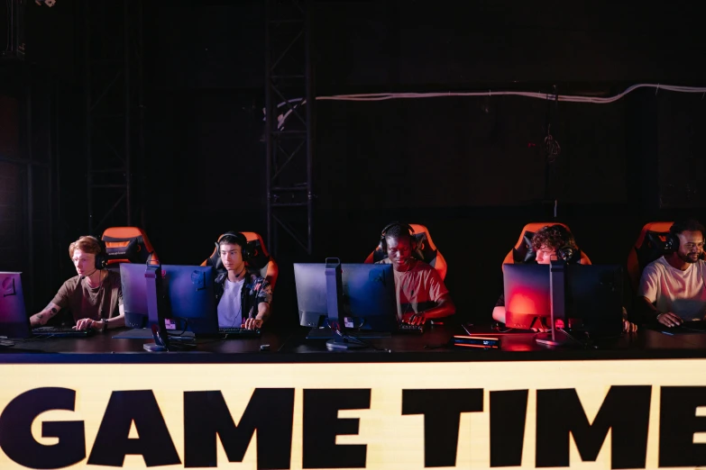 a group of people sitting at a table with laptops, by Matija Jama, unsplash, interactive art, gameshow, it's morbin time, esports logo, large led screens