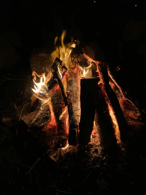 a person standing next to a fire in the dark, profile image, outdoor campfire pit, hyperdetailed photo, multiple stories