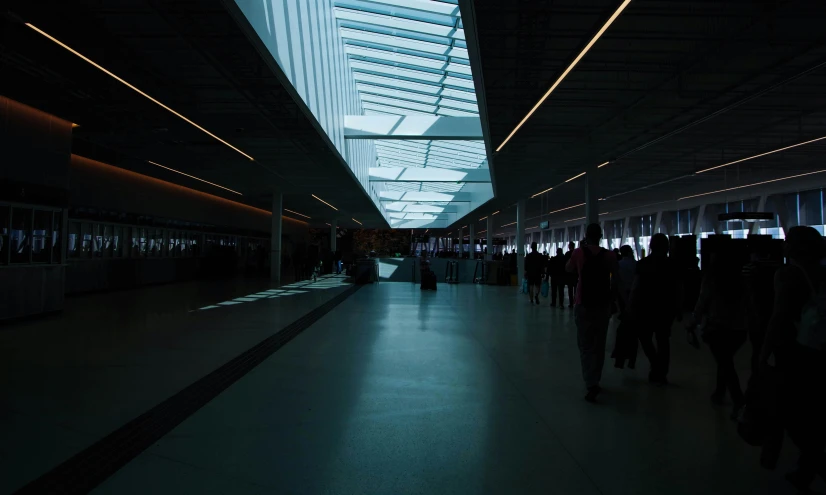 a group of people walking through a train station, inspired by Elsa Bleda, light and space, portal. zaha hadid, aykut aydogdu, ground-level view, illuminated lines