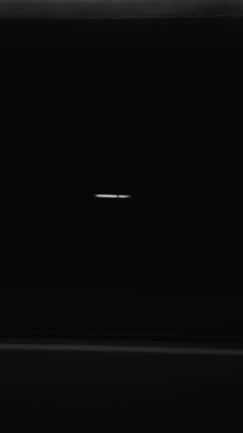 a black and white photo of a plane in the sky, inspired by Ryoji Ikeda, hurufiyya, white moon and black background, saturn, seen from a plane, floodlight