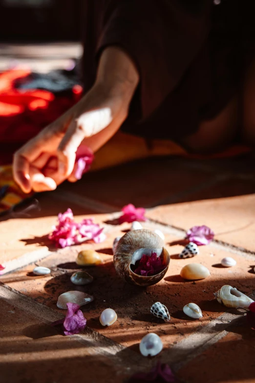 a person cutting a doughnut with a pair of scissors, by Julia Pishtar, trending on unsplash, process art, in an ancient altar, embedded with gemstones, anjali mudra, petals