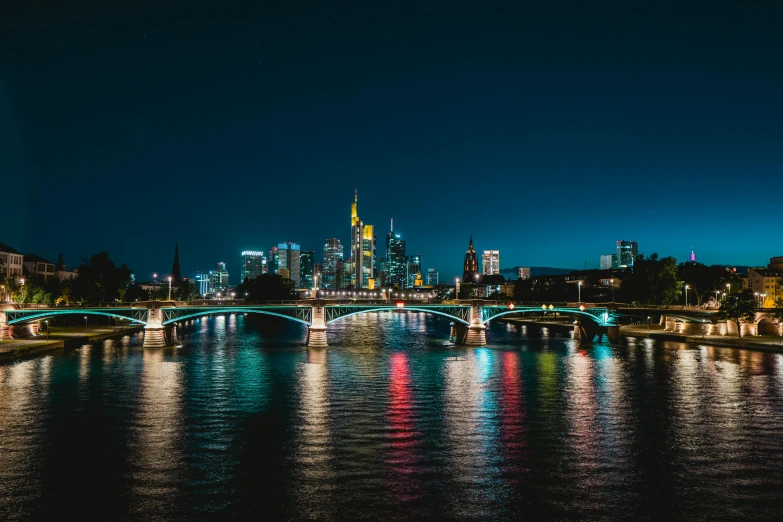 the city skyline is lit up at night, by Niko Henrichon, pexels contest winner, the river is full of lights, plain background, german, unsplash photography