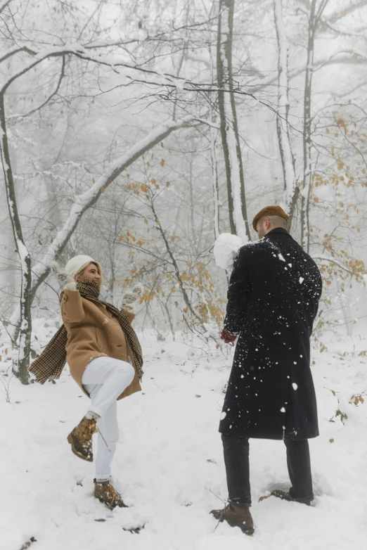 a couple of people that are standing in the snow, twirling, snowing in the forest, february)