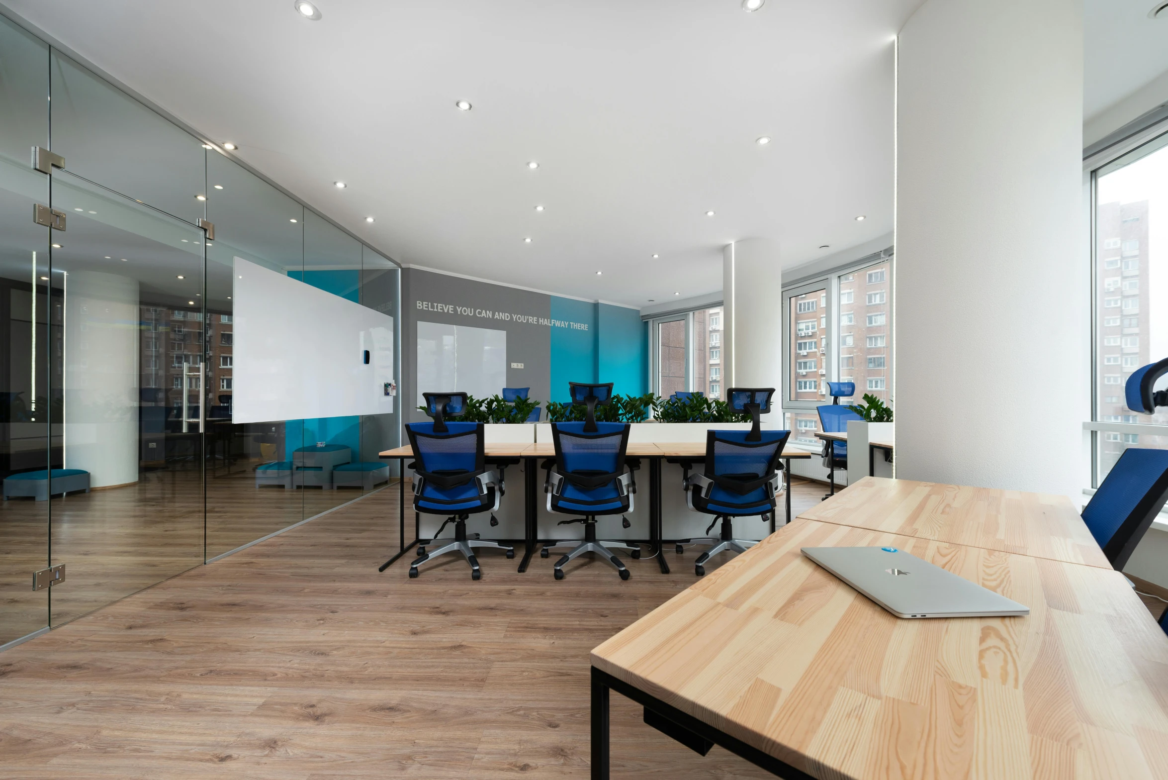 a conference room with a wooden table and blue chairs, by david rubín, unsplash, 9 9 designs, open office, casually dressed, full - view