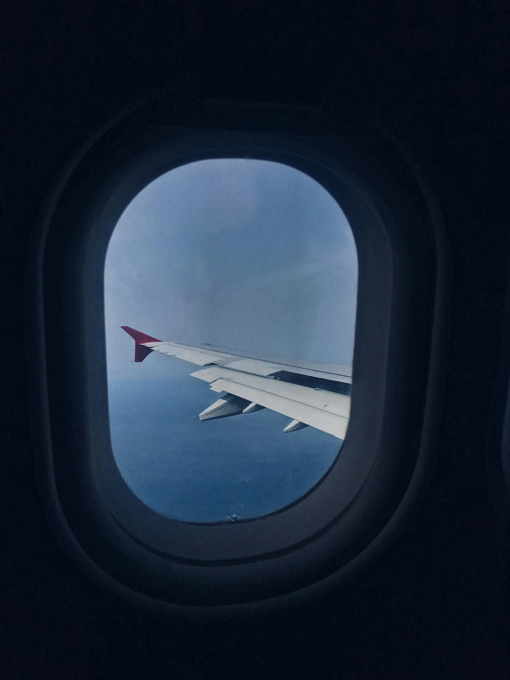 a view of the wing of an airplane through a window, by Jessie Algie, pexels contest winner, surrealism, photo of the middle of the ocean, trending on vsco, looking out at a red ocean, wanderers traveling from afar