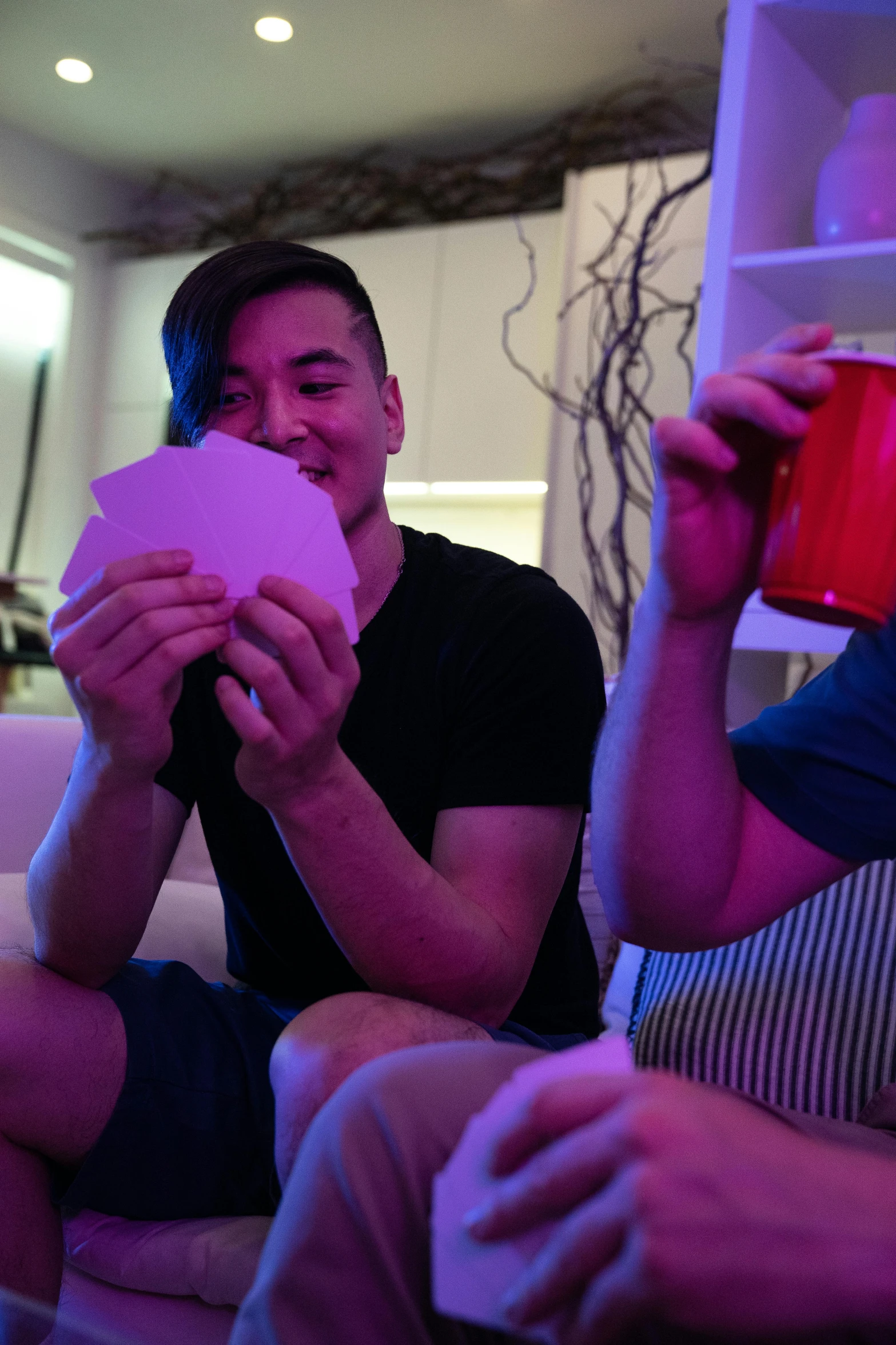 a couple of men sitting on top of a couch, reddit, holds playing cards, greg rutkowski and ross tran, at the party, vivid)