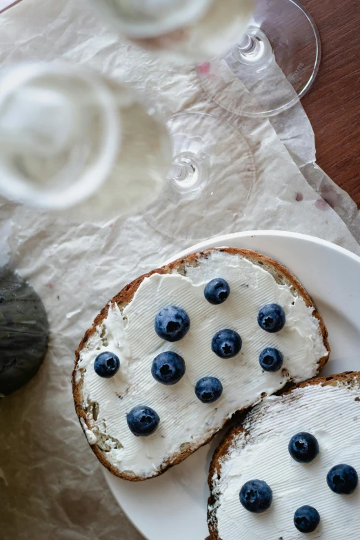 a white plate topped with bread covered in blueberries, pexels contest winner, sparkling water, anna nikonova, white freckles, artisanal art