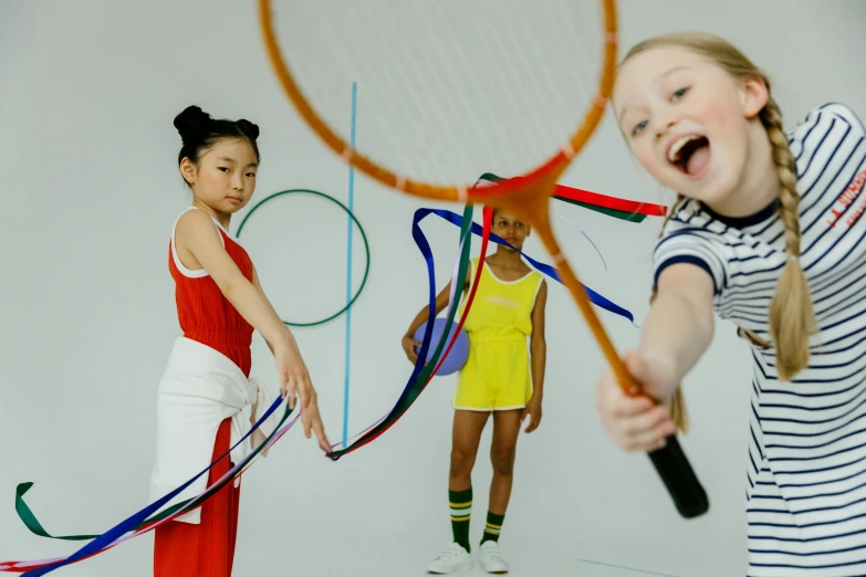 a couple of girls standing next to each other holding tennis racquets, pexels contest winner, interactive art, chinese ribbon dance, primary colours, eva elfie, ; wide shot