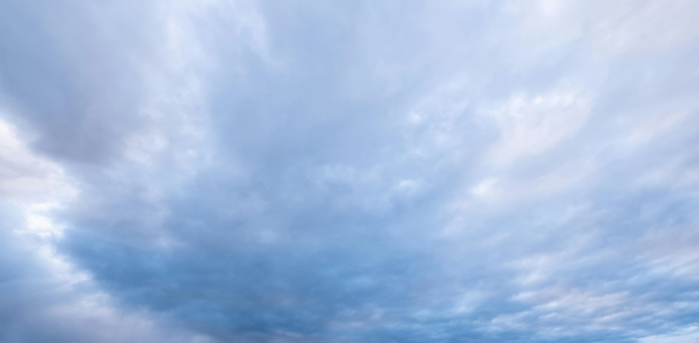 a group of people riding skis on top of a snow covered slope, an album cover, unsplash, minimalism, mammatus clouds, soft blue texture, panorama view of the sky, low angle 8k hd nature photo