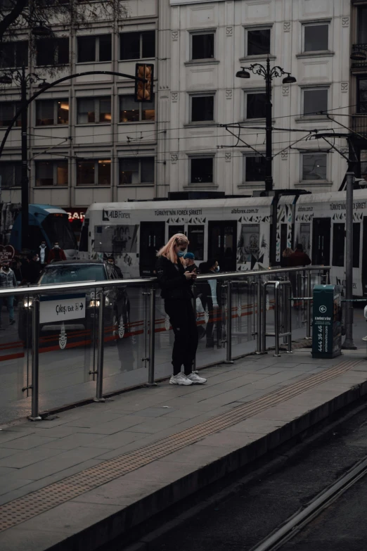 a woman waiting for a train at a train station, by Christen Dalsgaard, unsplash, standing on street corner, trams, low quality photo, norwegian man