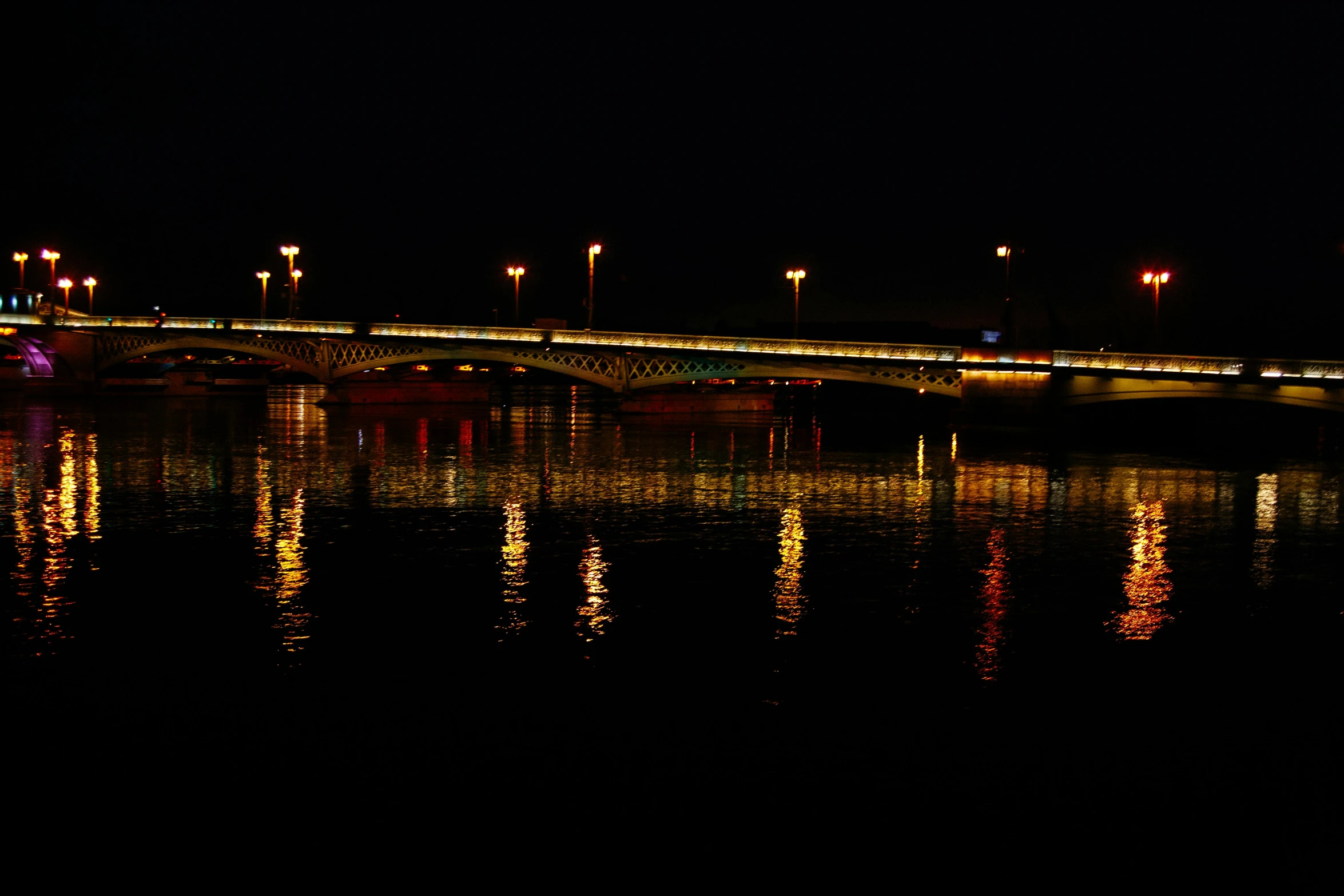 a bridge over a body of water at night, a picture, pexels contest winner, hurufiyya, indore, reflective light, side lights, 2022 photograph