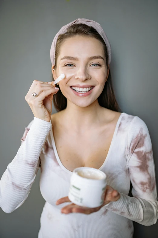 a beautiful young woman holding a cup of coffee, trending on pexels, renaissance, cream dripping on face, photoshoot for skincare brand, manuka, covered in