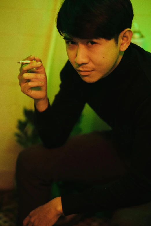 a man sitting on the floor holding a cigarette, inspired by Hideyuki Kikuchi, holding green fire, darren quach, ((portrait)), weed