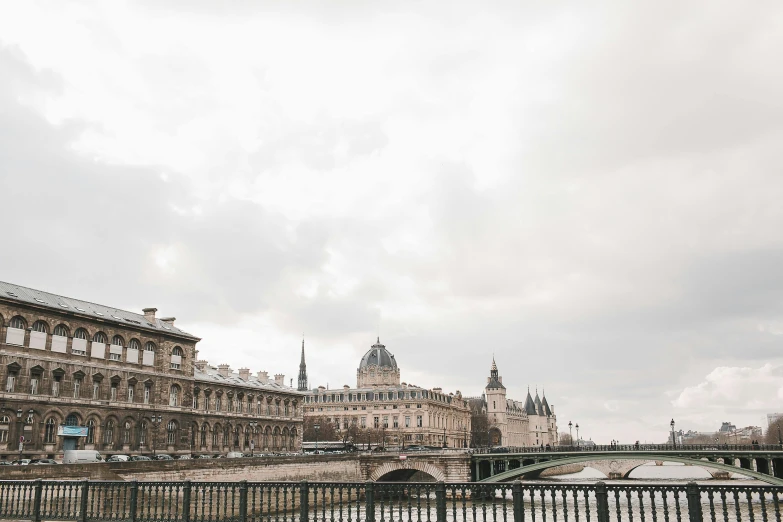 a bridge over a river with a building in the background, by Andrée Ruellan, trending on unsplash, paris school, overcast gray skies, royal palace, photographic print, winter photograph