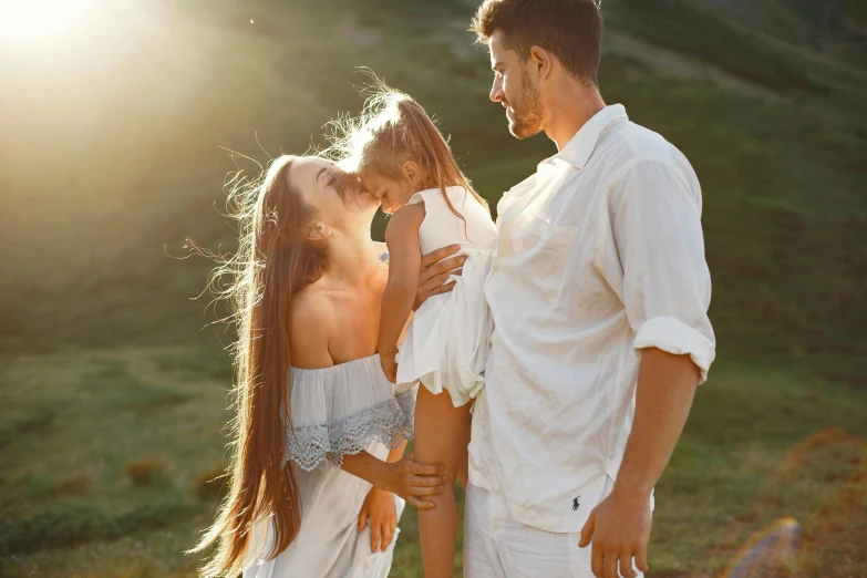 a man and woman standing next to each other in a field, pexels contest winner, father with child, white trendy clothes, sunny lighting, 15081959 21121991 01012000 4k