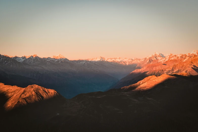 a view of the mountains from the top of a mountain, by Peter Churcher, pexels contest winner, warm glow, new zealand, uttarakhand, sunfaded