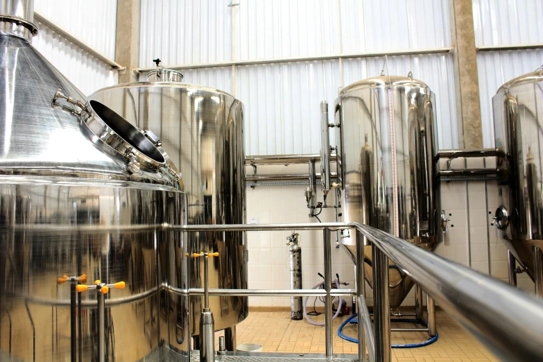 a row of stainless steel tanks inside of a building, by John Henderson, shutterstock, beer, instagram post, vanilla, 278122496