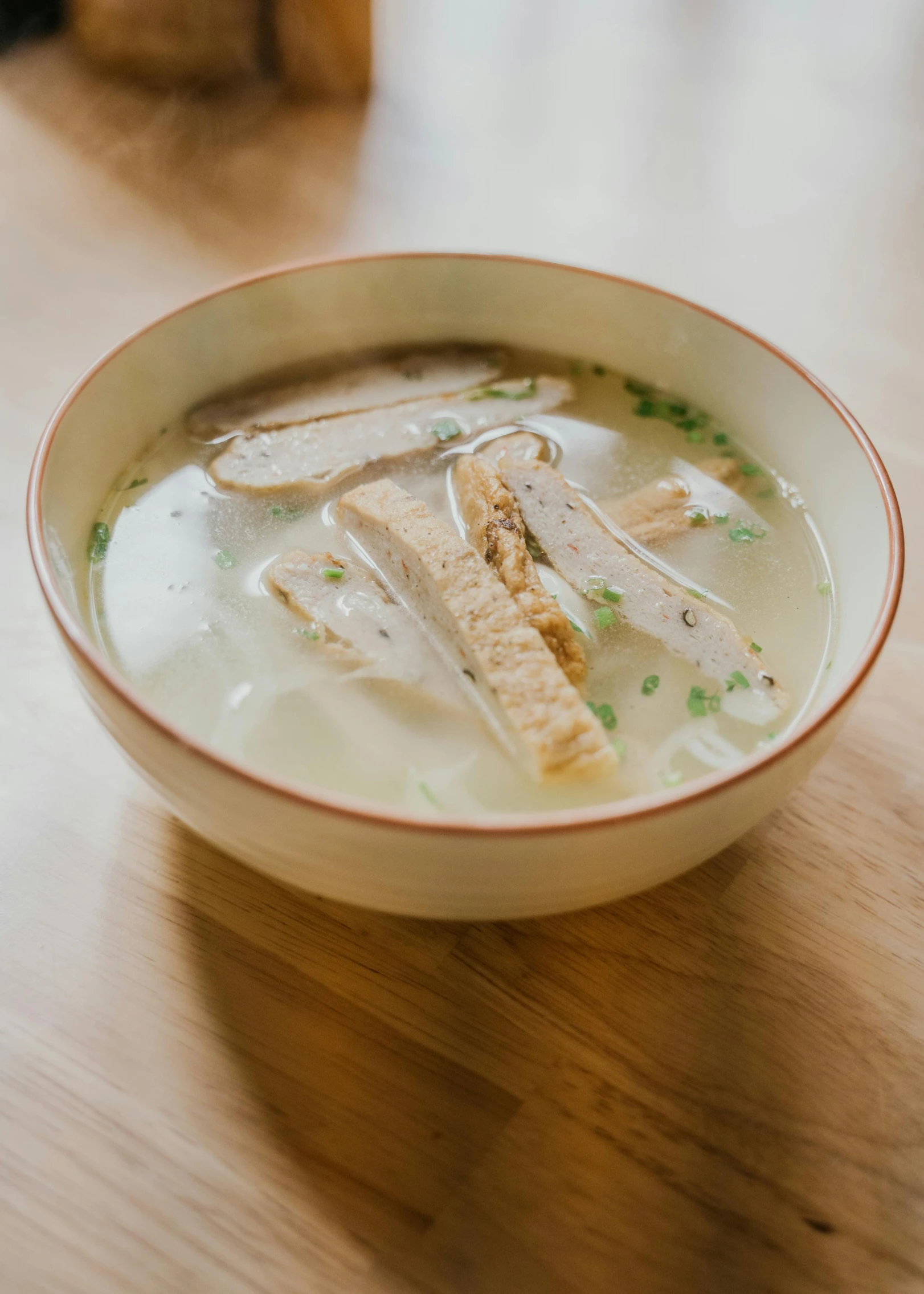 a bowl of soup sitting on top of a wooden table, jisu choe, light grey, square, thumbnail