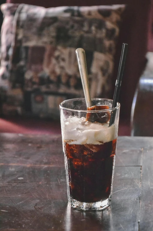 a drink sitting on top of a wooden table, spoon, ice coffee, in style of lam manh, soda