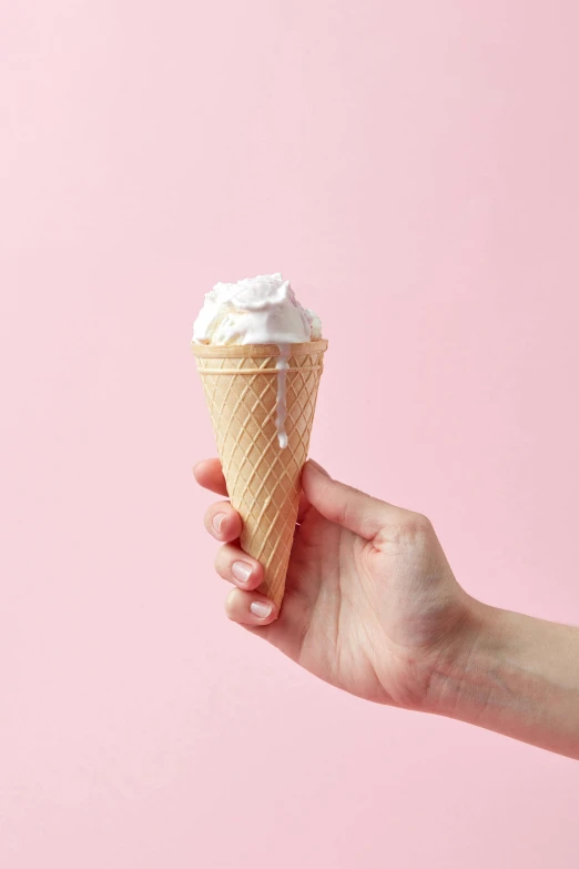 a hand holding an ice cream cone on a pink background, epicurious, medium, ivy's, profile image