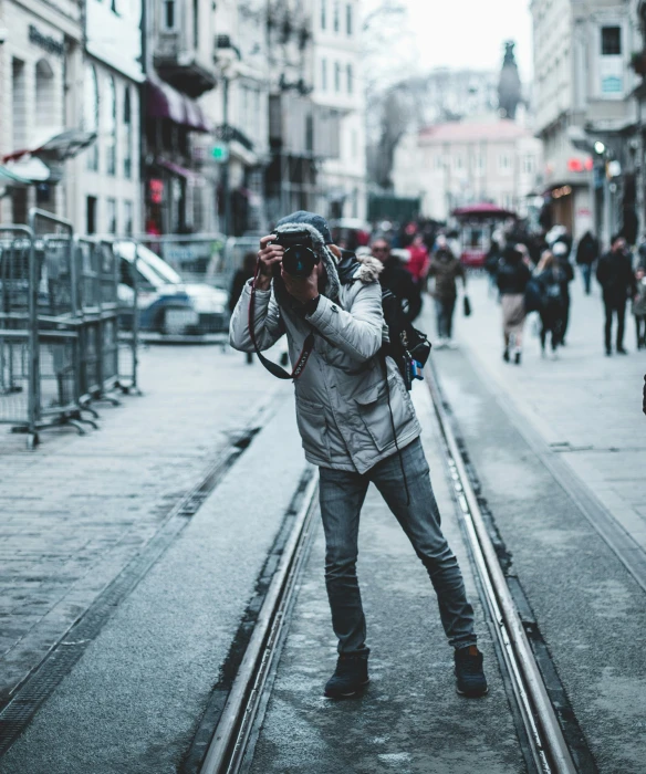 a man taking a picture of a street with a camera, by Adam Rex, pexels contest winner, happening, full body in camera, gray men, tripod, paparazzi photo