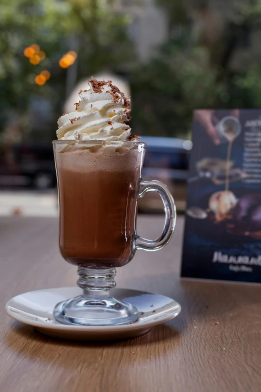 a close up of a cup of coffee on a table, chocolate river, hasbulla, whipped cream, marbella