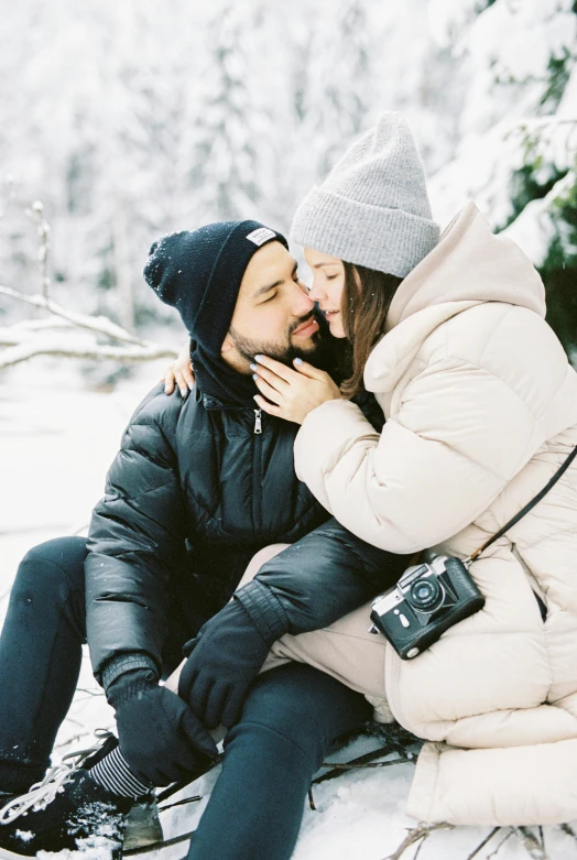 a man and woman sitting next to each other in the snow, pexels contest winner, pokimane, pregnant, profile image, man grabbing a womans waist