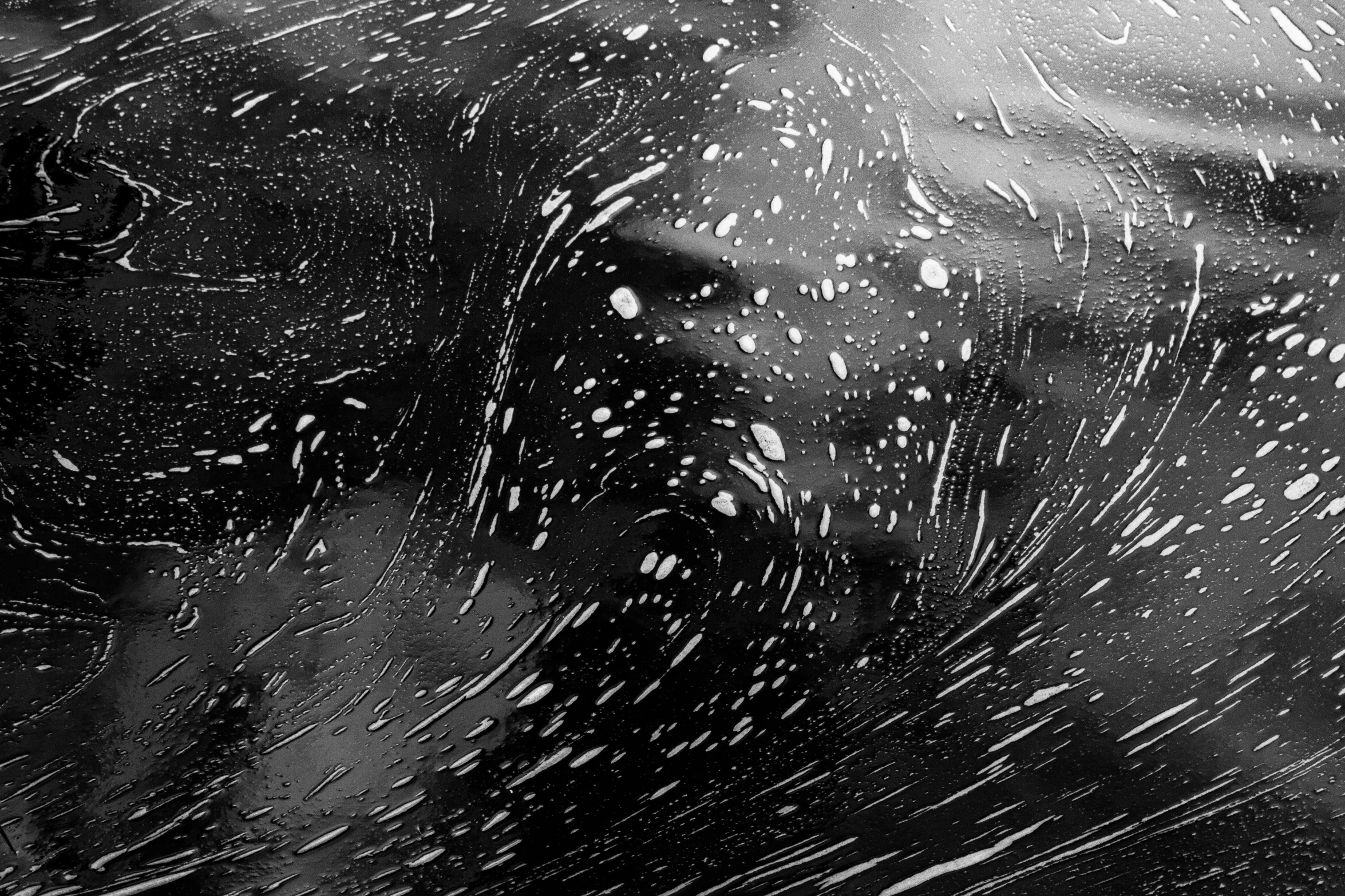 a black and white photo of a woman's face, a stipple, inspired by Vija Celmins, pexels, kinetic pointillism, wild ocean storm at night, covered with ferrofluid. dslr, rippling reflections, driving rain