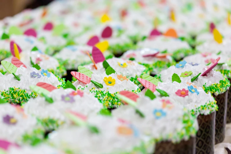 a table topped with lots of cupcakes covered in frosting, by Adam Marczyński, spring theme, thumbnail, fairies, close up details