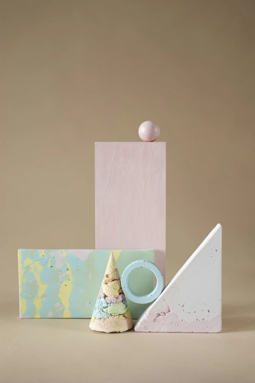 a group of objects sitting on top of a table, an abstract sculpture, inspired by Eden Box, pastel texture, ice cream cone, splatters, full product shot