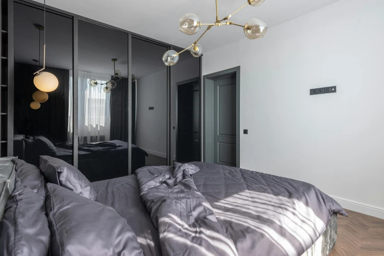 a bed room with a neatly made bed and a chandelier, by Adam Marczyński, unsplash, bauhaus, flying black marble balls, 3 doors, high quality photo, glossy white metal