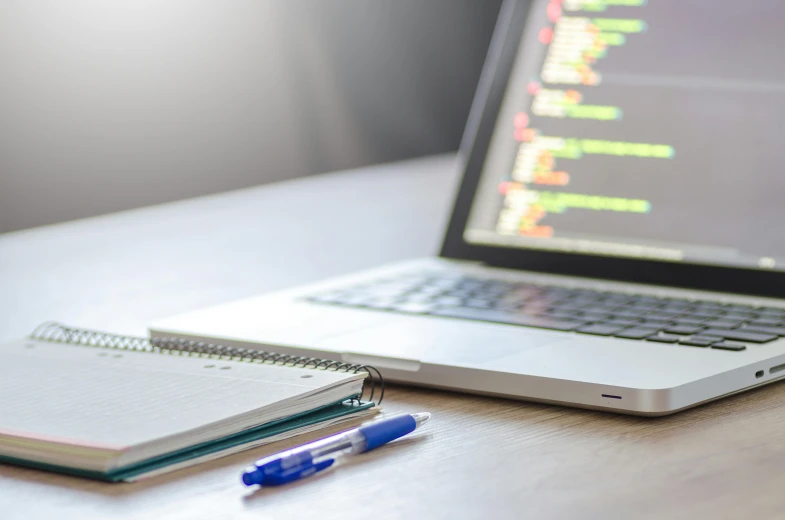 a laptop computer sitting on top of a wooden desk, a computer rendering, by Robbie Trevino, unsplash, beautiful code, pen and paper, multiple stories, a close-up