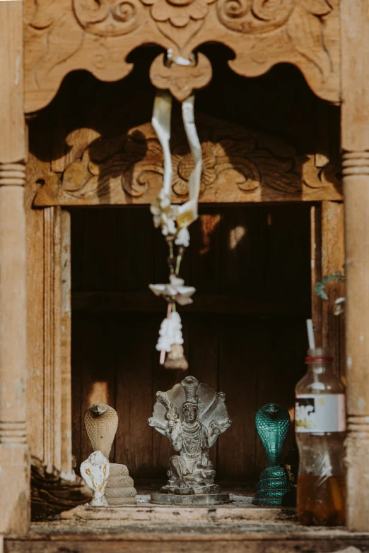 a statue of jesus hanging from the side of a building, a picture, unsplash, antique perfume, from inside a temple, an unknown ethnographic object, cottage close up