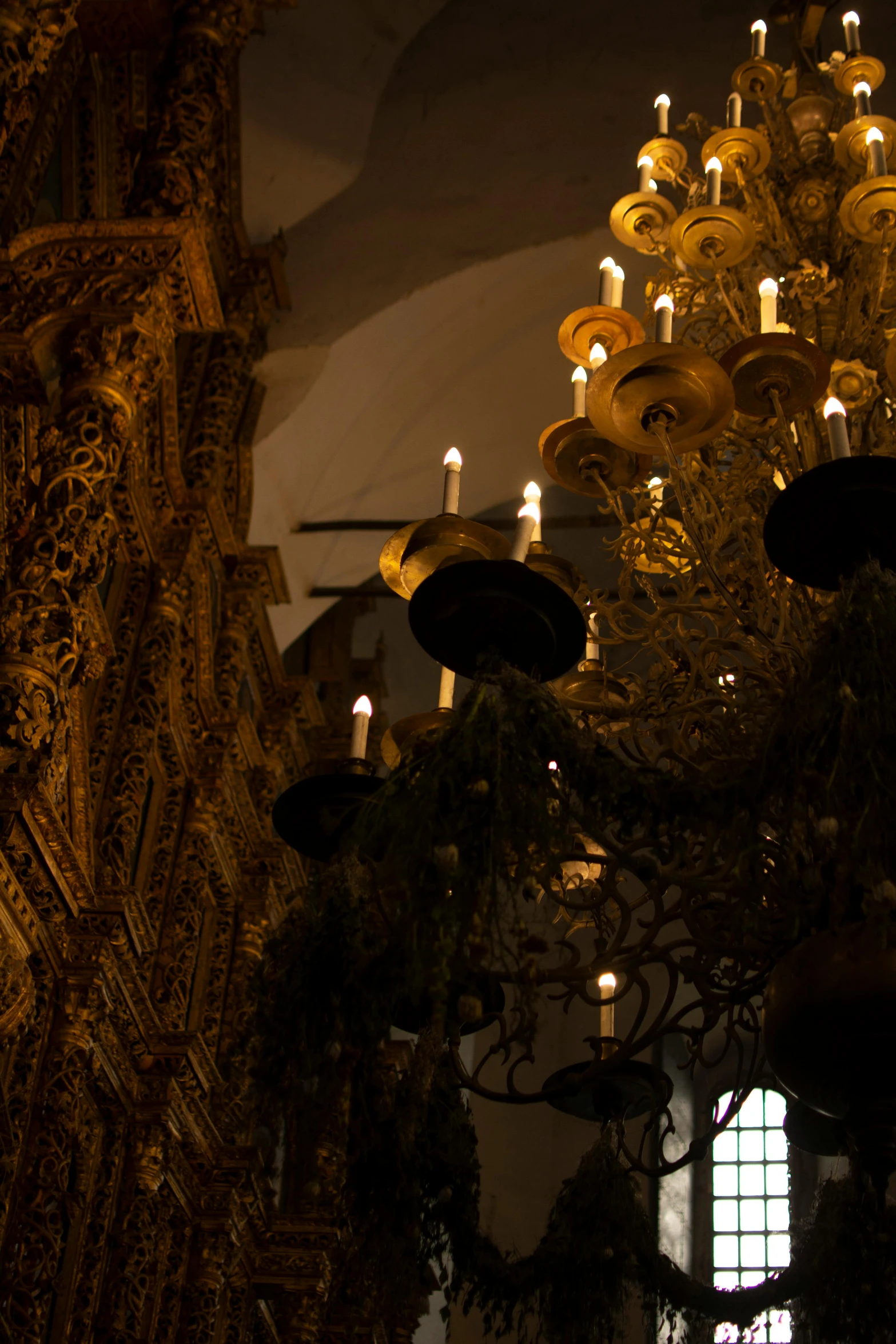 a chandelier hanging from the ceiling of a church, inspired by Luis Paret y Alcazar, baroque, candles, seville, cosy atmosphere, sconces