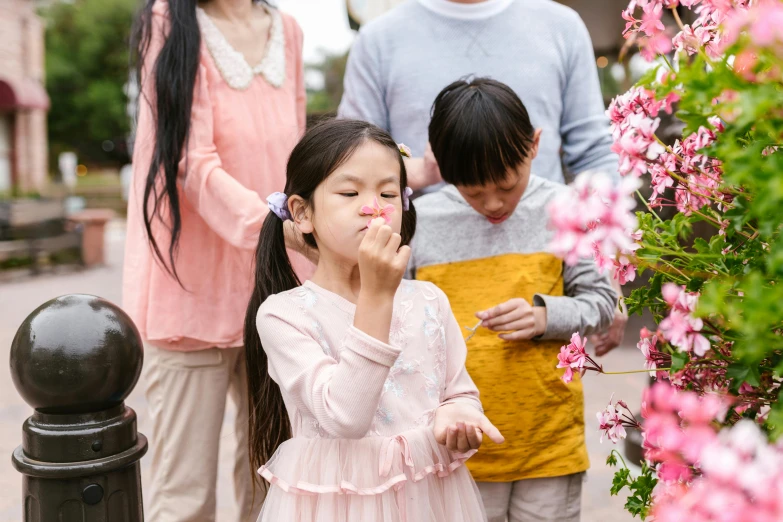 a group of people standing around a little girl, pexels contest winner, japanese related with flowers, coughing, avatar image, manuka