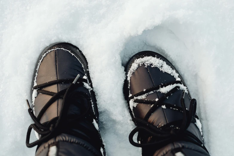 a person standing in the snow wearing black shoes, trending on pexels, crisp face, ready to eat, detailed shot legs-up, thumbnail