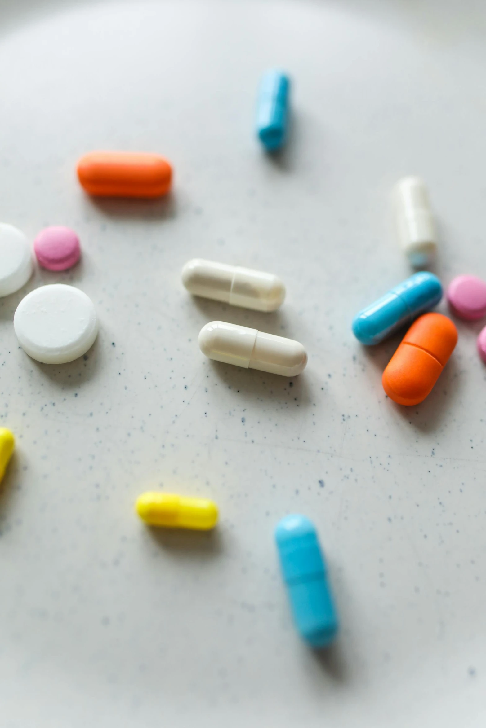 a white plate topped with lots of different colored pills, pexels, antipodeans, chartreuse and orange and cyan, on a gray background, orelsan, multiple stories