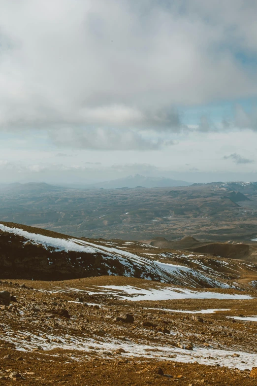 a man standing on top of a snow covered mountain, by Muggur, trending on unsplash, les nabis, panorama distant view, in chuquicamata, low quality photo, wales