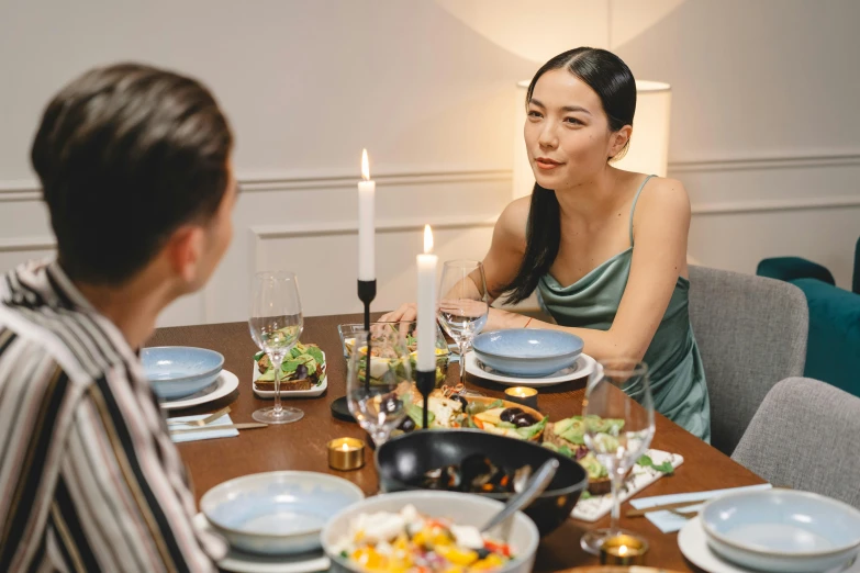 a couple of people that are sitting at a table, at a dinner table, gemma chen, ready to eat, profile image