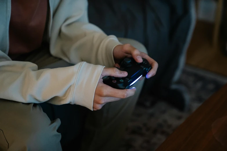 a person sitting on a couch holding a video game controller, inspired by Elsa Bleda, pexels, avatar image, brown, gaming room, instagram post