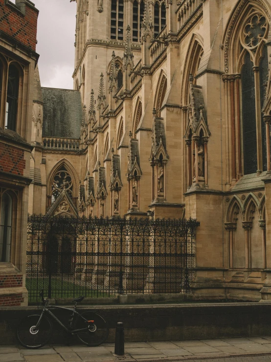 a bike is parked in front of a church, by IAN SPRIGGS, unsplash, renaissance, buttresses, rows of doors, 1990s photograph, many stone statues