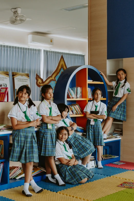 a group of girls in school uniforms posing for a picture, a picture, inspired by Sasha Putrya, pexels contest winner, book shelf small library, 3/4 front view, well-designed masterpiece, indonesia