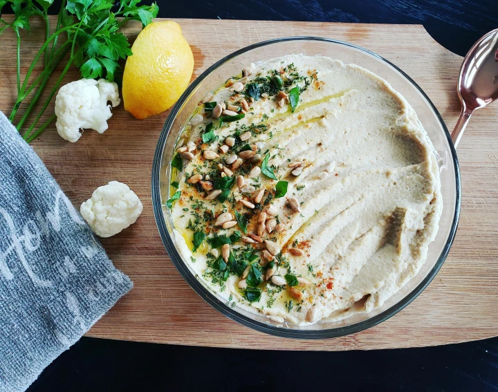 a wooden cutting board topped with a bowl of hummusle, pexels contest winner, hurufiyya, humus, middle eastern skin, veggies, 🤬 🤮 💕 🎀