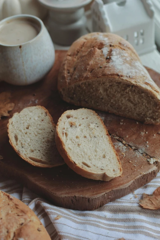 a loaf of bread sitting on top of a wooden cutting board, a portrait, unsplash, cottagecore, round-cropped, malt, sparkling