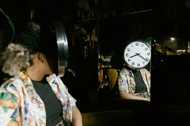 a woman standing in front of a mirror with a clock on it, pexels contest winner, kara walker, trapped in the backrooms, sitting alone at a bar, mechanical clock